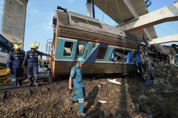 Los equipos de rescate operan entre los escombros luego de que una grúa de construcción cayera sobre un tren de pasajeros, Tailandia. - Sputnik Mundo