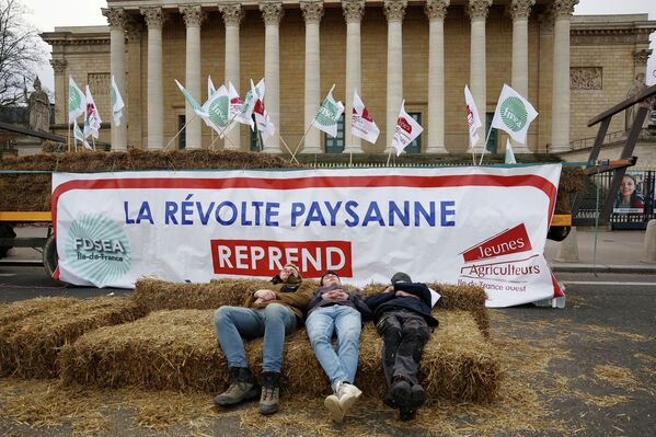 Agricultores franceses duermen sobre fardos de paja frente al edificio del Parlamento de Francia durante las protestas contra el acuerdo de libre comercio Mercosur-UE y contra la política agrícola del Gobierno francés. - Sputnik Mundo