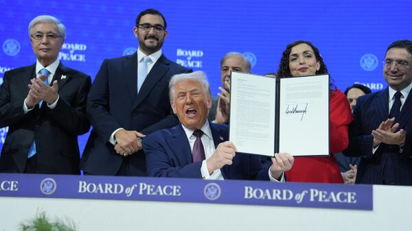 El presidente Donald Trump, en el centro, sostiene una carta firmada de la Carta del Consejo de Paz durante la Reunión Anual del Foro Económico Mundial en Davos, Suiza - Sputnik Mundo