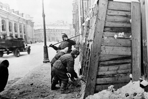 Además del pedestal del caballo de Clodt, en el puente Aníchkov, las huellas de los impactos de metralla se preservan en los escalones y columnas de la fachada occidental de la catedral de San Isaac y en la fachada norte de la Iglesia de la Resurrección de Cristo.En la foto: los ciudadanos comienzan a retirar las protecciones defensivas de las casas de la calle Sadóvaya. - Sputnik Mundo