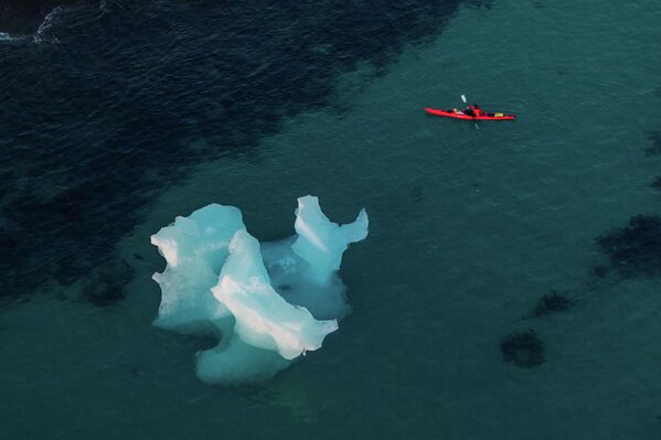 Un individuo rema en kayak junto a un iceberg cerca de Nuuk, Groenlandia. - Sputnik Mundo