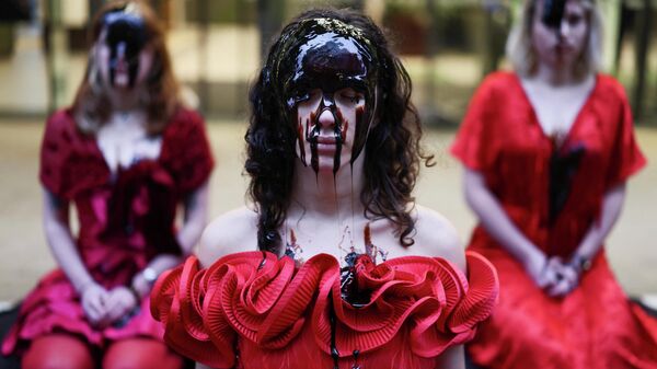Activistas con vestidos de rosas rojas y rostros cubiertos de melaza en una protesta por un derrame de petróleo, en Londres, Reino Unido.  - Sputnik Mundo