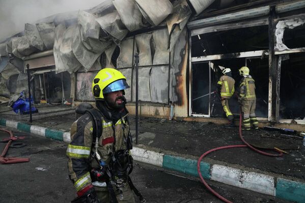 Los bomberos trabajan para extinguir un incendio en el mercado de Jannat, en el oeste de Teherán, Irán. - Sputnik Mundo