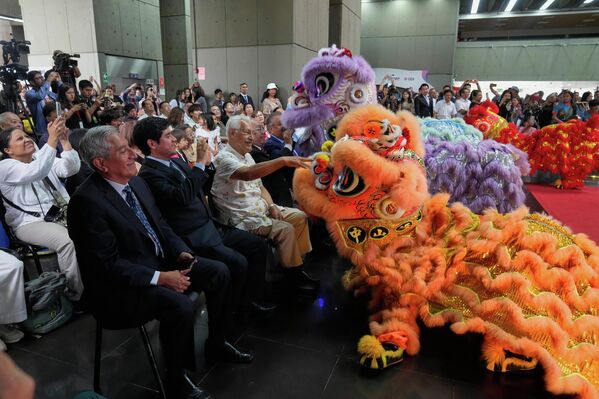 La gente interactúa con los asistentes al Año Nuevo chino vestidos como leones, durante un evento en el Ministerio de Cultura en Lima, Perú. - Sputnik Mundo