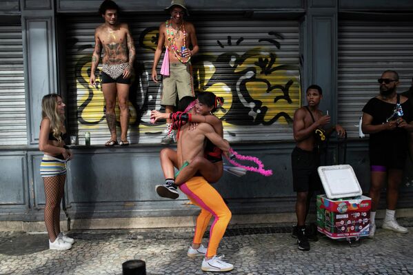 Unas personas que se abrazan en la fiesta callejera previa al Carnaval Nada Demais, en Río de Janeiro. - Sputnik Mundo