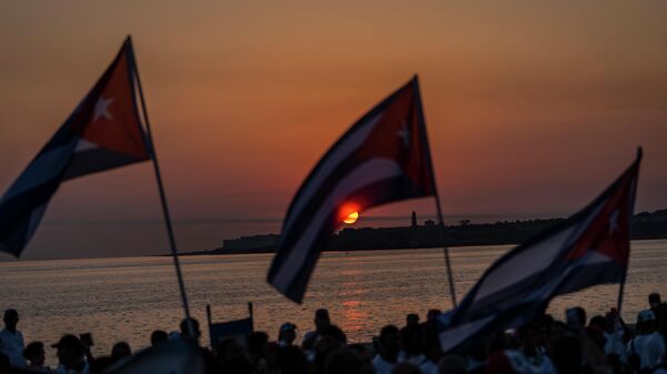 La gente sostiene banderas cubanas durante una celebración del Día de los Trabajadores en La Habana, Cuba, el 5 de mayo de 2023  - Sputnik Mundo