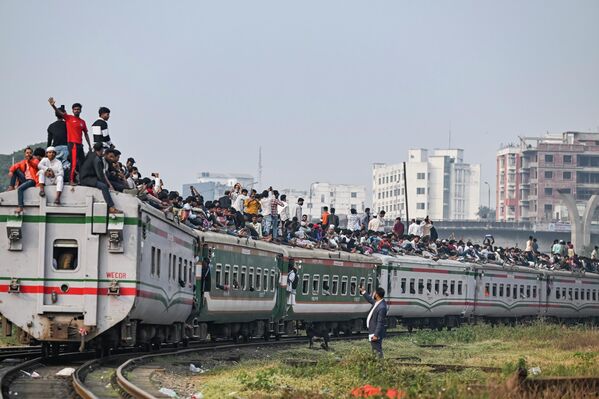 Los habitantes de Bangladés abandonan la ciudad de Daca y viajan en el techo del tren en la estación de tren de Kamalapur en la capital bangladesí. Las personas se dirigen a su ciudad natal para emitir sus votos antes de las elecciones al Parlamento del país.  - Sputnik Mundo