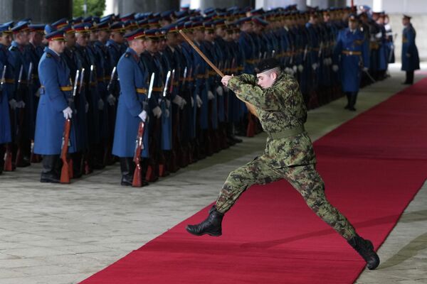 Un miembro de la guardia de honor serbia salta sobre la alfombra roja sosteniendo una escoba, antes de una ceremonia de bienvenida para el presidente de Azerbaiyán, Ilham Aliev, en Belgrado.  - Sputnik Mundo