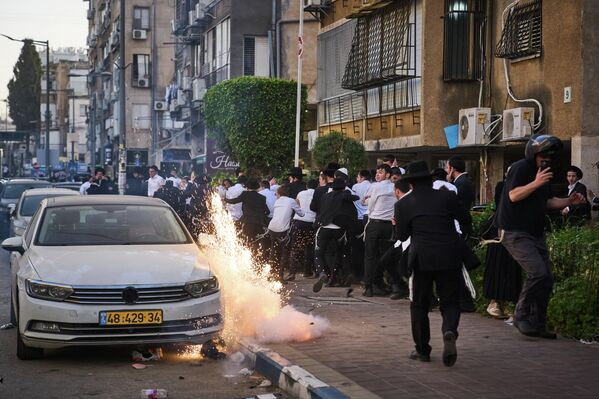 Una granada aturdidora explota durante enfrentamientos entre la Policía y judíos ultraortodoxos, después de que dos mujeres soldados israelíes fueran rescatadas de los disturbios que estallaron durante una visita de asistencia social en Bnei Brak, Israel. - Sputnik Mundo
