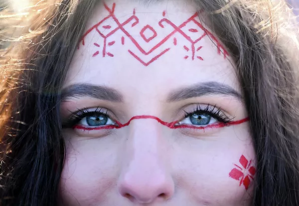 La storia della Maslenitsa risale all'epoca precristiana. Gli slavi orientali celebravano questa festa, collegandola ai rituali di saluto all'inverno e di benvenuto alla primavera. Tradizioni simili esistevano anche tra altri popoli indoeuropei, a simboleggiare il rinnovamento della natura e l'inizio di un nuovo ciclo. Secondo una versione, la festa era dedicata al dio slavo della terra Veles, protettore del bestiame e della fertilità. Secondo un'altra, rappresentava l'addio all'inverno e il risveglio della terra. Coincideva con l'equinozio di primavera, quando il sole iniziava a vincere il freddo. Nella foto: il volto di una giovane donna dipinto con ornamenti pagani slavi. La storia di Maslenitsa risale all'epoca precristiana. Gli slavi orientali celebravano questa festa, collegandola ai rituali di addio all'inverno e di benvenuto alla primavera. Tradizioni simili esistevano anche tra altri popoli indoeuropei, a simboleggiare il rinnovamento della natura e l'inizio di un nuovo ciclo. Secondo una versione, la festa era dedicata al dio slavo della terra Veles, protettore del bestiame e della fertilità. Secondo un'altra, rappresentava la fine dell'inverno e il risveglio della terra. Coincideva con l'equinozio di primavera, quando il sole iniziava a vincere il freddo. Nella foto: il volto di una giovane donna dipinto con ornamenti pagani slavi. - Sputnik Mundo