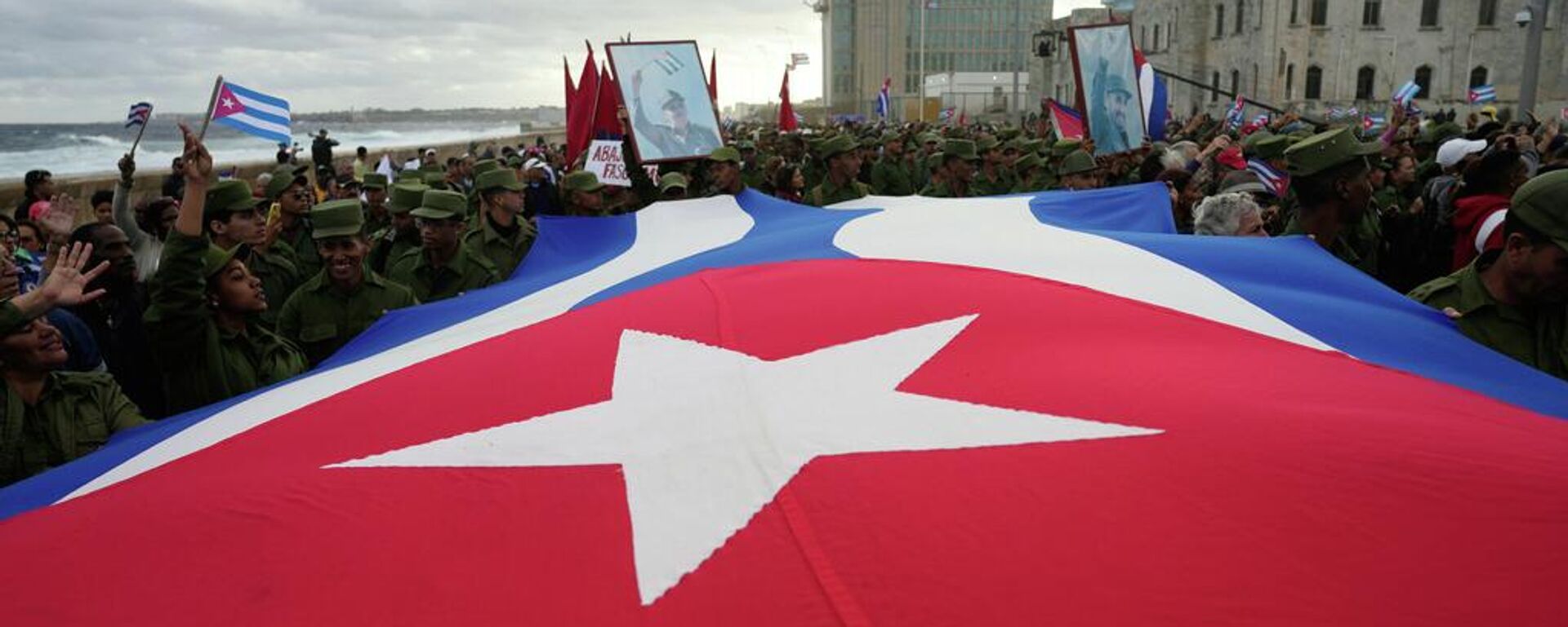 Personas portan una bandera cubana en La Habana, Cuba - Sputnik Mundo, 1920, 28.02.2026