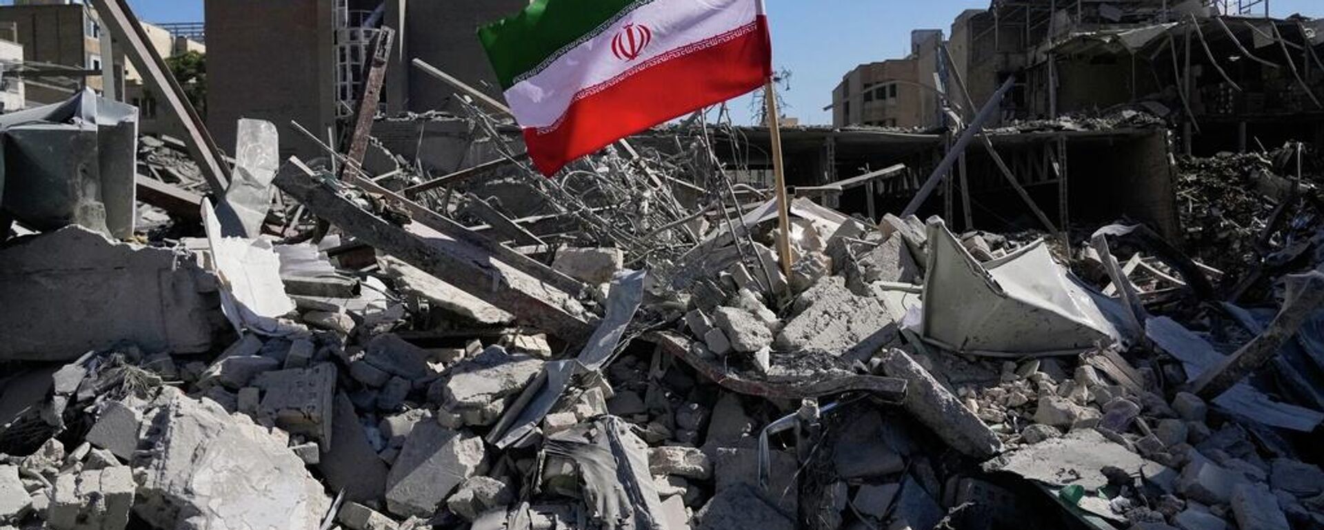 Una bandera iraní colocada entre las ruinas de una comisaría de policía atacada durante la campaña militar estadounidense-israelí en Teherán, el 3 de marzo de 2026 - Sputnik Mundo, 1920, 08.03.2026