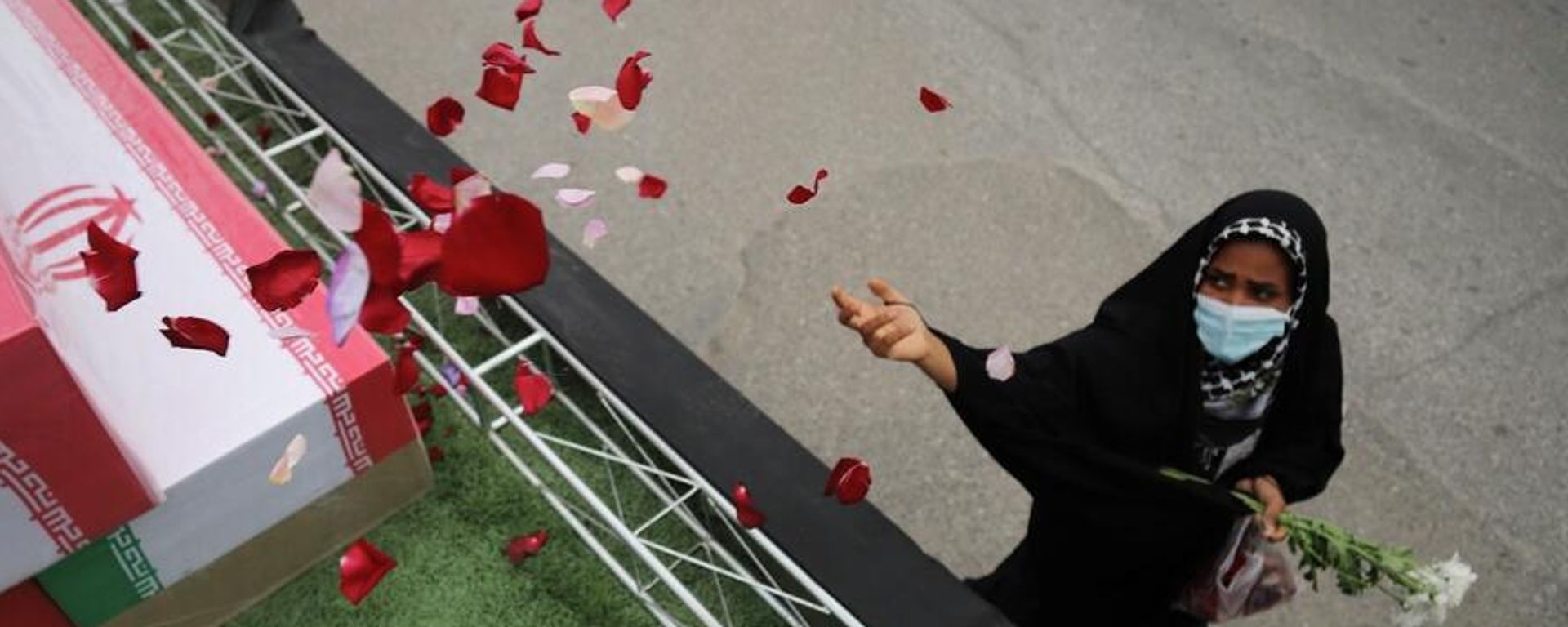 Una mujer arroja pétalos de rosa sobre ataúdes - Sputnik Mundo, 1920, 18.07.2026