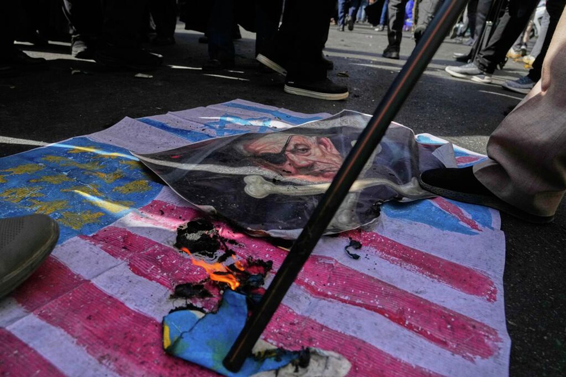 Una representación de las banderas de EEUU e Israel y un retrato satirizado del primer ministro israelí, Benjamin Netanyahu, son incendiados durante una manifestación anual frente a la antigua embajada de EEUU en Teherán, en conmemoración del aniversario de la toma de posesión de la embajada en 1979. Irán, el martes 4 de noviembre de 2025 - Sputnik Mundo, 1920, 07.03.2026