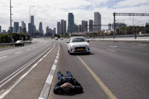 Alerta de un ataque con misiles obligó a un ciudadano israelí de esperar tumbado sobre la carretera como medida de precaución. - Sputnik Mundo