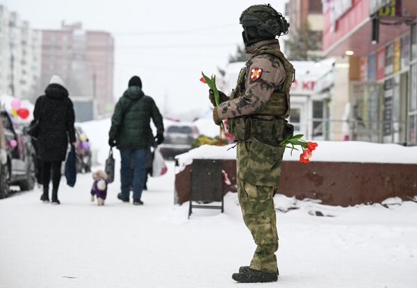 Un cadete ruso reparte flores a las mujeres que pasan por la calle con motivo del Día Internacional de la Mujer en la ciudad de Novosibirsk. - Sputnik Mundo