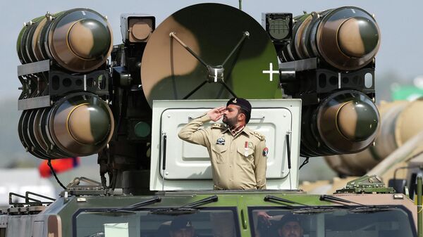 Un soldado del Ejército pakistaní saluda mientras está de pie sobre un sistema de misiles de defensa aérea durante el desfile militar del Día de Pakistán en Islamabad, Pakistán, el 23 de marzo de 2022  - Sputnik Mundo