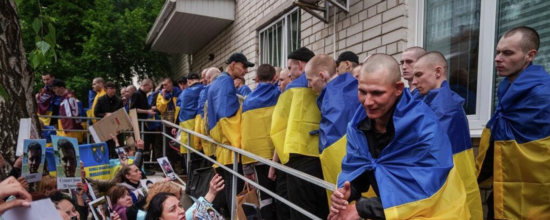 Familiares de soldados ucranianos desaparecidos y encarcelados muestran fotografías a militares devueltos de su cautiverio en un intercambio de prisioneros de guerra en Ucrania, el 6 de mayo de 2025 - Sputnik Mundo, 1920, 18.03.2026