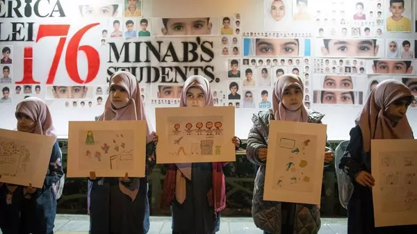 Las niñas sostienen en sus manos dibujos en memoria de las alumnas fallecidas en un ataque estadounidense-israelí perpetrado el 28 de febrero contra la escuela de Minab. - Sputnik Mundo