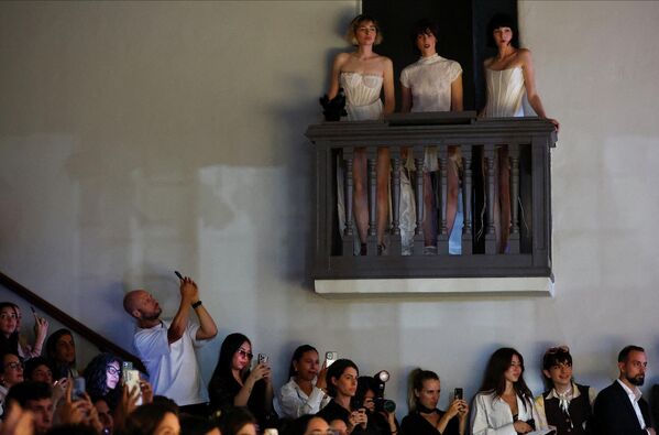 Un espectador sacando fotos a las modelos durante el desfile de la diseñadora Valentina Shukhner en la Semana de la Moda de Buenos Aires. - Sputnik Mundo