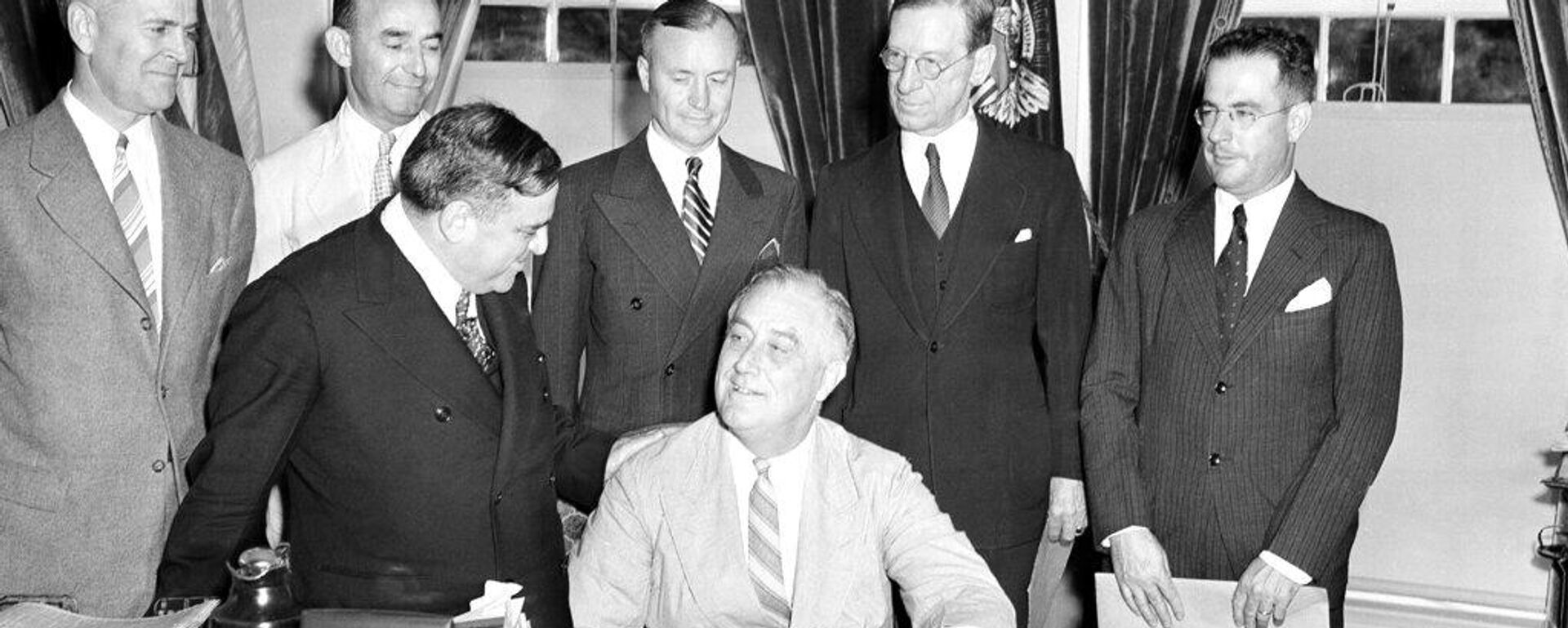 El presidente de EEUU, Franklin D. Roosevelt, en la Oficina Oval de la Casa Blanca junto a funcionarios y colaboradores, en 1940 - Sputnik Mundo, 1920, 23.03.2026