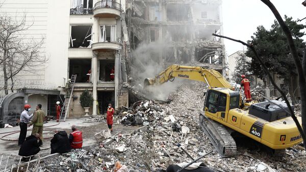 El personal de emergencia trabaja en el lugar de un ataque contra un edificio residencial, en medio del conflicto entre Estados Unidos e Israel con Irán, en Teherán, Irán, el 23 de marzo de 2026 - Sputnik Mundo