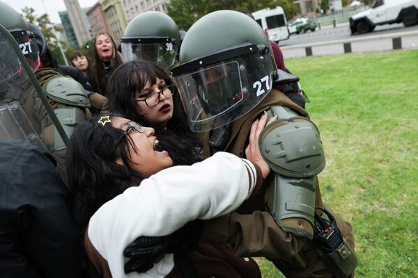 Manifestantes se enfrentan a la Policía antidisturbios frente al palacio presidencial de La Moneda durante una marcha para conmemorar el Día Mundial del Agua en Santiago de Chile. - Sputnik Mundo