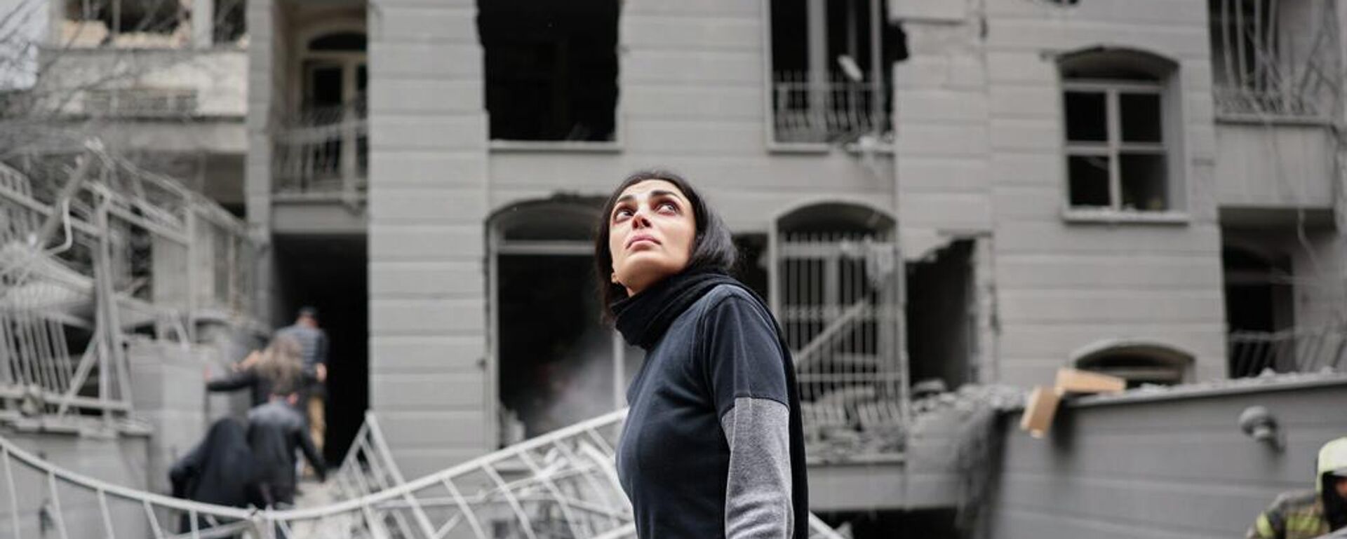 Una mujer mira hacia arriba en el lugar donde un ataque aéreo impactó un edificio residencial en Teherán, Irán. - Sputnik Mundo, 1920, 28.03.2026