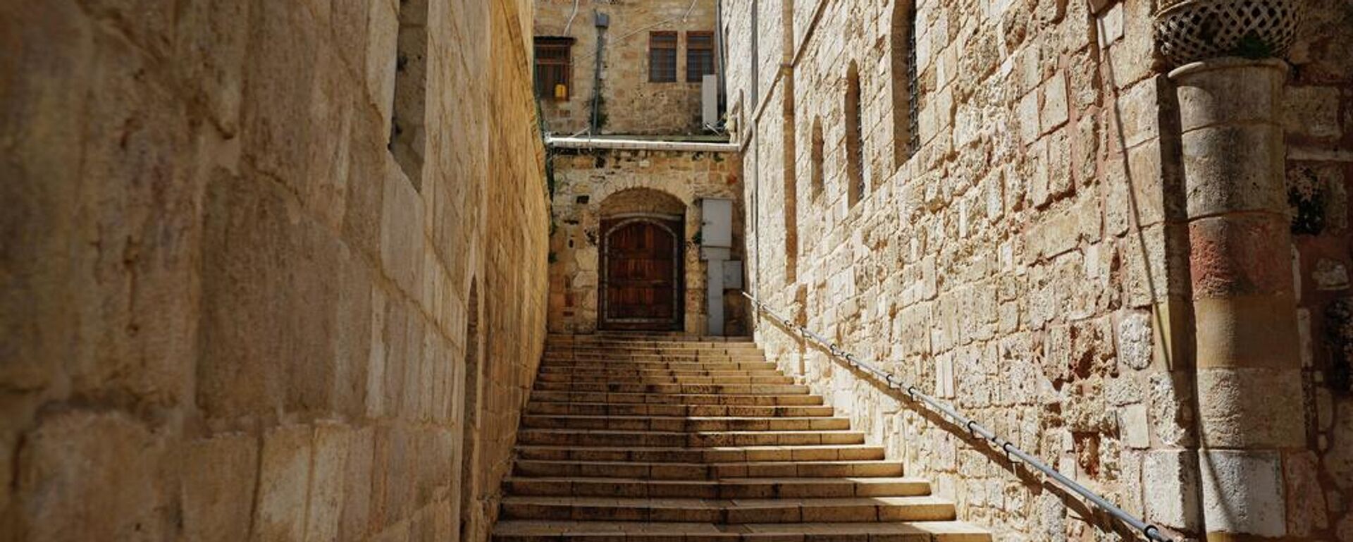 Una puerta cerrada con llave y unas escaleras vacías conducen a la Iglesia del Santo Sepulcro en la Ciudad Vieja de Jerusalén. - Sputnik Mundo, 1920, 29.03.2026