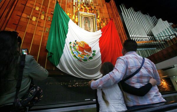 Una familia visita la imagen de la Virgen de Guadalupe en la Ciudad de México - Sputnik Mundo