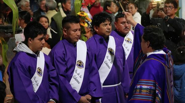Un sacerdote bendice a los feligreses durante una procesión nocturna de Semana Santa en Puellaro, Ecuador, el martes 31 de marzo de 2026. (Foto AP/Dolores Ochoa) - Sputnik Mundo