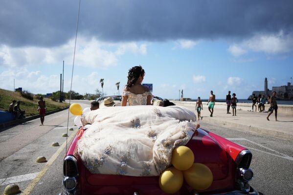 Una quinceañera viaja en un automóvil antiguo durante la celebración de su cumpleaños en La Habana, Cuba. - Sputnik Mundo