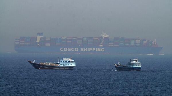 Dos dhows tradicionales navegan junto a un gran buque portacontenedores en el estrecho de Ormuz, 19 de mayo de 2023  - Sputnik Mundo