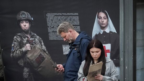 La gente frente a un cartel que muestra la historia del Ejército ucraniano, en Kiev, Ucrania - Sputnik Mundo