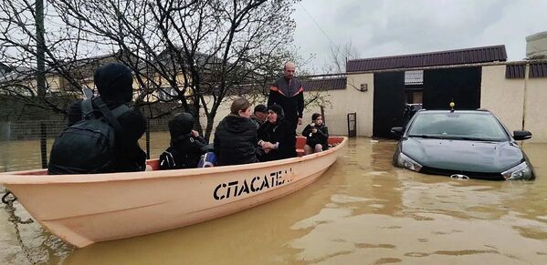 Rescatistas evacúan a personas de casas residenciales inundadas en Derbent, Rusia. Decenas de domicilios en la república de Daguestán sufrieron daños graves por las corrientes de agua que llegaron tras la ruptura de una presa en el embalse. - Sputnik Mundo