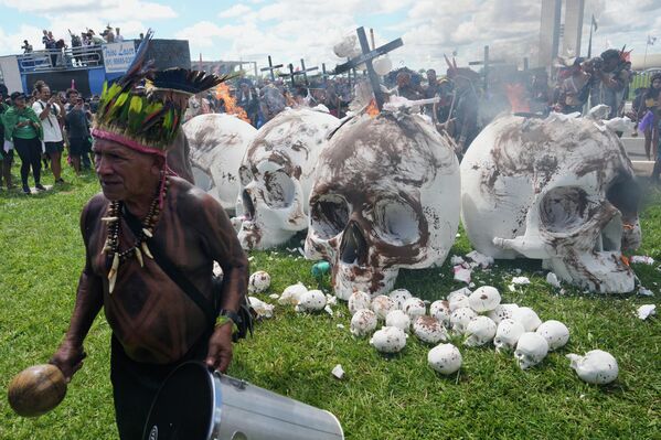 Indígenas prenden fuego a esculturas de cráneos que simbolizan a los legisladores frente al edificio del Congreso durante la acción Campamento Tierra Libre, la mayor movilización anual de los pueblos indígenas de Brasil, dedicada a los derechos sobre la tierra y la protección del medio ambiente, Brasilia, Brasil. - Sputnik Mundo