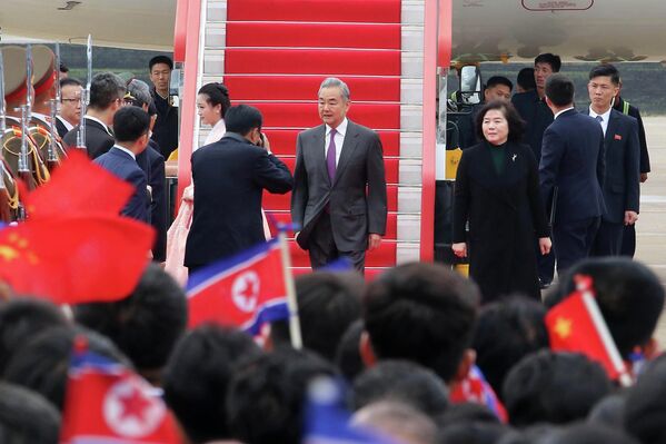 El ministro de Asuntos Exteriores de China, Wang Yi, en el centro, llega al aeropuerto internacional de Piongyang, Corea del Norte. A la derecha se ve a la ministra de Exteriores de Corea del Norte, Choe Son-hui. - Sputnik Mundo