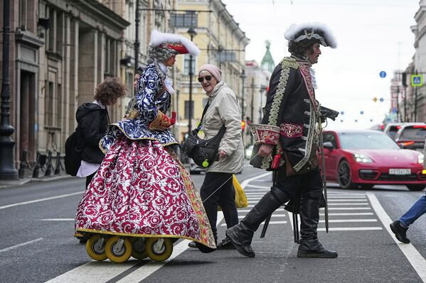 Un artista callejero que representa al zar ruso Pedro el Grande jala a la figura de la emperatriz sobre ruedas por las calles de San Petersburgo, Rusia. - Sputnik Mundo