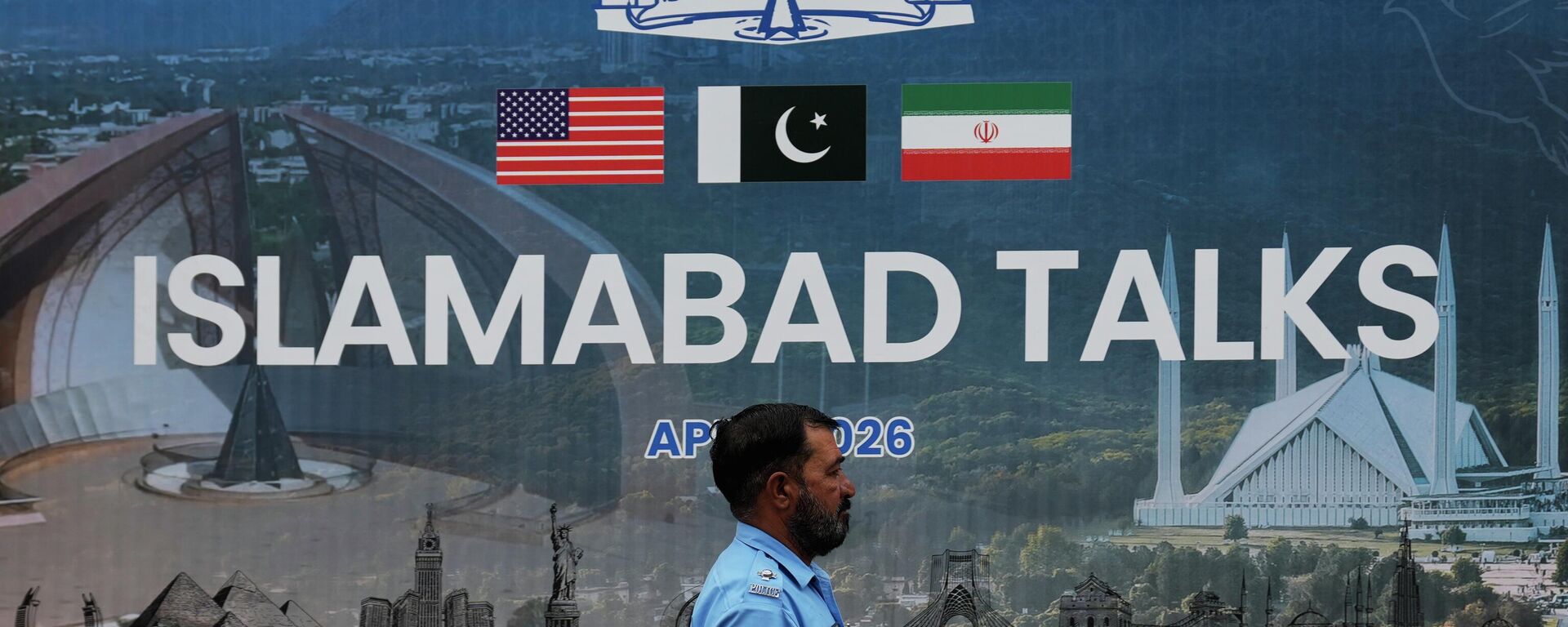 Un agente de Policía pasa junto a una valla publicitaria sobre las negociaciones entre Estados Unidos e Irán, frente a un centro de atención a los medios de comunicación en Islamabad, Pakistán, el 11 de abril de 2026 - Sputnik Mundo, 1920, 13.04.2026