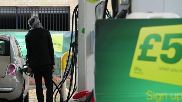 Un hombre llena de gasolina su automóvil en una gasolinera BP en Londres - Sputnik Mundo