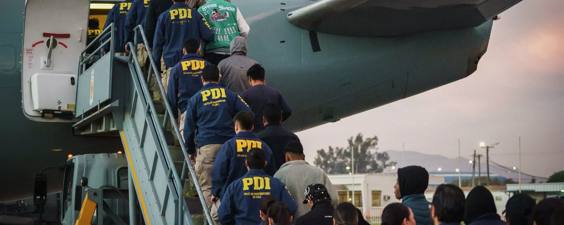 Migrantes irregulares en Chile siendo deportados en un vuelo, escoltados por efectivos de la Policía de Investigaciones (PDI) en abril de 2026 - Sputnik Mundo, 1920, 17.04.2026