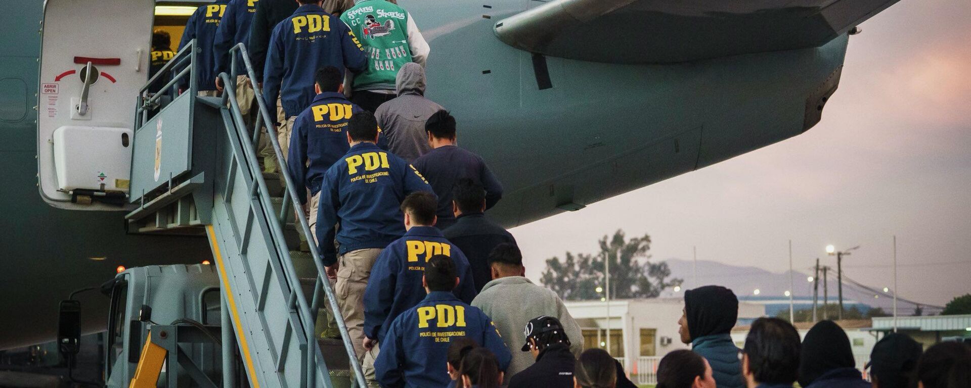 Migrantes irregulares en Chile siendo deportados en un vuelo, escoltados por efectivos de la Policía de Investigaciones (PDI) en abril de 2026 - Sputnik Mundo, 1920, 17.04.2026