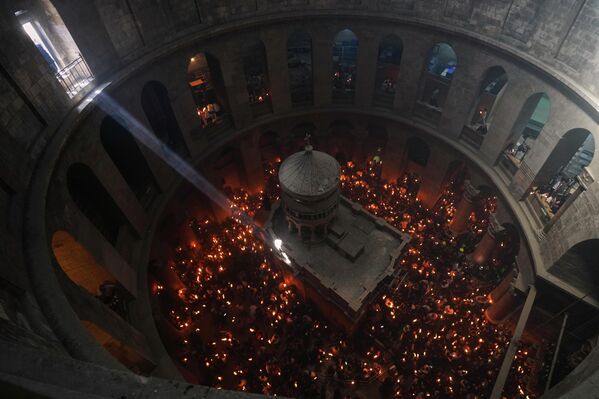 Los peregrinos cristianos ortodoxos encienden velas durante la ceremonia del Fuego Sagrado en la Iglesia del Santo Sepulcro, el lugar donde, según la tradición, Jesús fue enterrado en la Ciudad Vieja de Jerusalén. - Sputnik Mundo