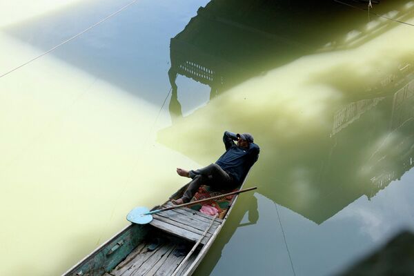 Un barquero descansa a la sombra en su shikara en un día soleado, en las aguas del río Jhelum, en Srinagar, en la región de Cachemira, India. - Sputnik Mundo