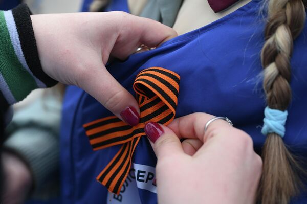 Una cinta de San Jorge ajustada en la chaqueta de una persona. - Sputnik Mundo