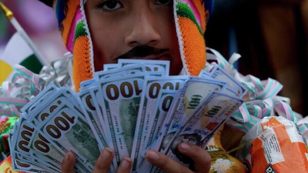 Hombre sosteniendo un fajo de billetes en Bolivia - Sputnik Mundo