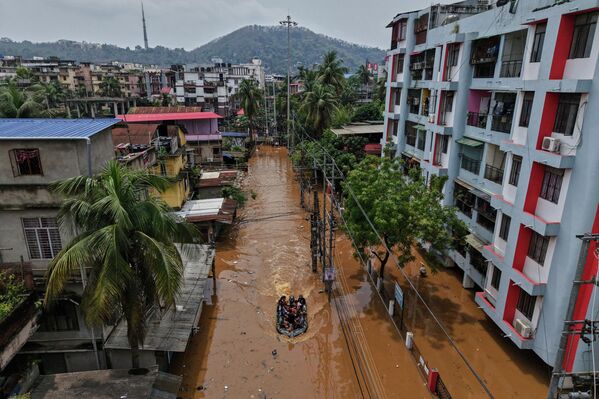 Personal de la Fuerza de Respuesta a Desastres del Estado (SDRF) viaja en una embarcación para rescatar a personas afectadas tras las fuertes lluvias premonzónicas en una carretera inundada en Guwahati, India. - Sputnik Mundo