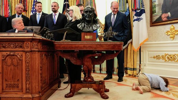 Travis Smith, quien recibió una terapia experimental de Regeneron tras ser diagnosticado con la mutación del gen OTOF, está tumbado en el suelo durante un acto sobre salud con el presidente de EEUU, Donald Trump en la Casa Blanca. - Sputnik Mundo