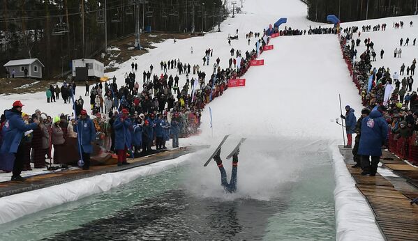 En el festival anual Gornoluzhnik en la ciudad rusa de Krasnoyarsk, participantes con disfraces temáticos intentan cruzar una piscina de 25 metros sobre esquís o snowboards. - Sputnik Mundo