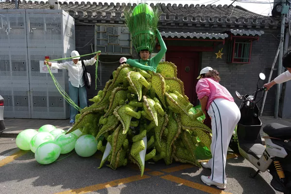La artista china Kong Ning viste un traje hecho con globos de dinosaurio para conmemorar el Día de la Tierra en Pekín, China. - Sputnik Mundo